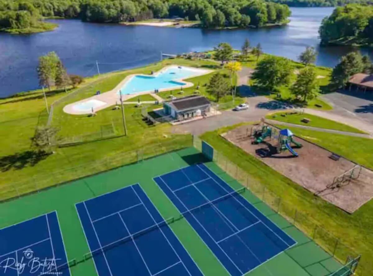 Aerial view of the community pools, tennis courts and playground by the lake