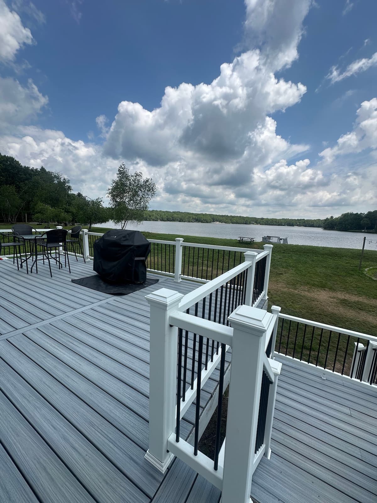 Deck with outdoor chairs and grill overlooking the lake